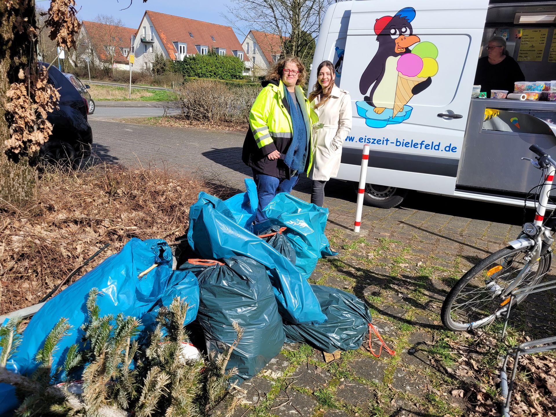 Zwei weibliche Personen stehen hinter Müllsäcken mit Müll, den sie gesammelt haben an einer Straße. Zwei weibliche Personen stehen hinter Müllsäcken mit Müll, den sie gesammelt haben an einer Straße.